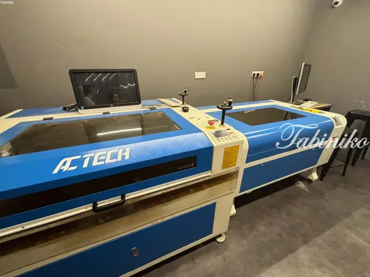 Large blue ACTECH laser cutting machine with control panel and monitor in a workshop.