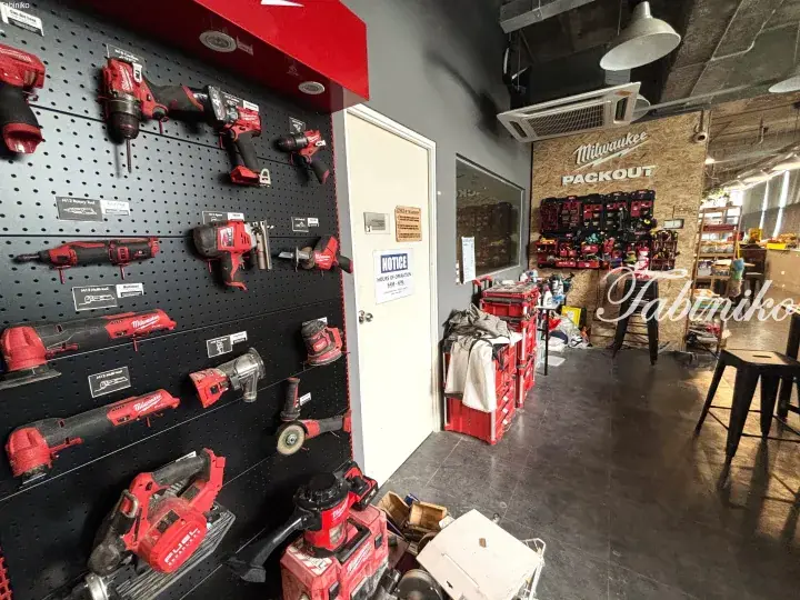 Milwaukee Packout power tools and storage organized on pegboard and shelves in a workshop.