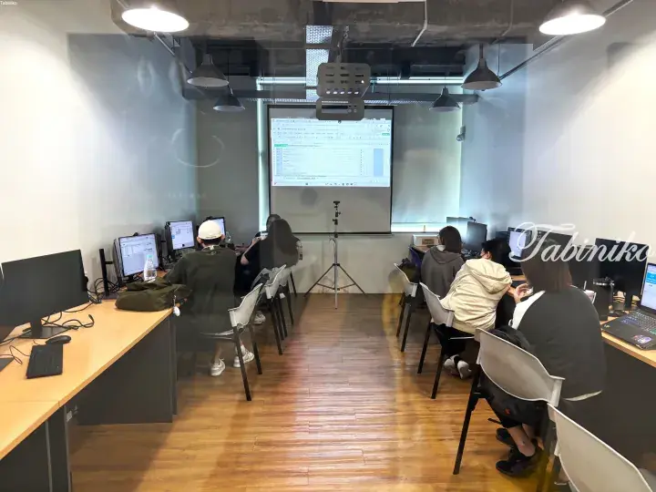Students attending a digital marketing workshop in a modern co-working space with a projector screen.