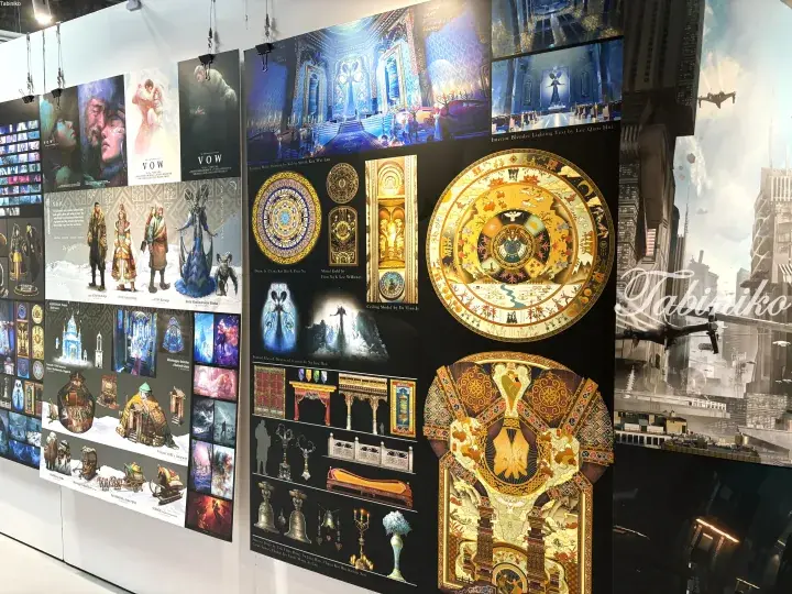 Concept art for a fantasy project featuring ornate golden mandalas, detailed character designs, and architectural blueprints displayed at an exhibition.