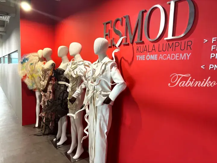 ESMOD Kuala Lumpur fashion academy display featuring mannequins in avant-garde white and patterned outfits against a vibrant red wall.