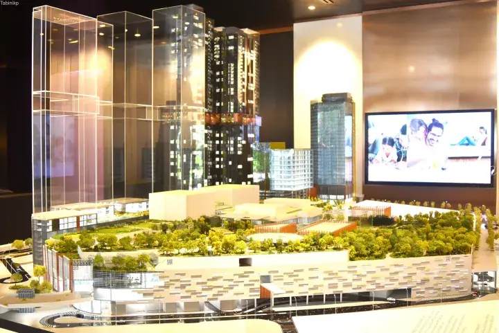 Architectural model showcasing a modern mixed-use development with high-rise towers, a landscaped rooftop park, and a commercial podium.