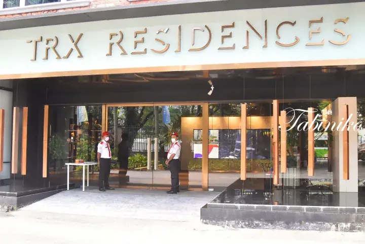 Entrance of TRX Residences with security guards standing at the glass doors.