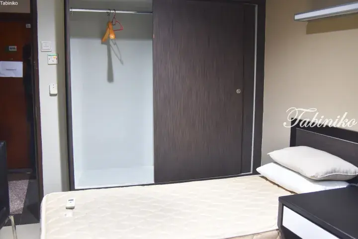 A bedroom with a single bed, mattress, and a wardrobe with sliding doors in a Malaysian property.