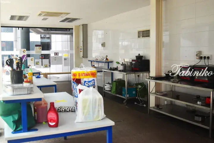 A clean kitchen area with stainless steel tables, appliances, and supplies in a modern building.