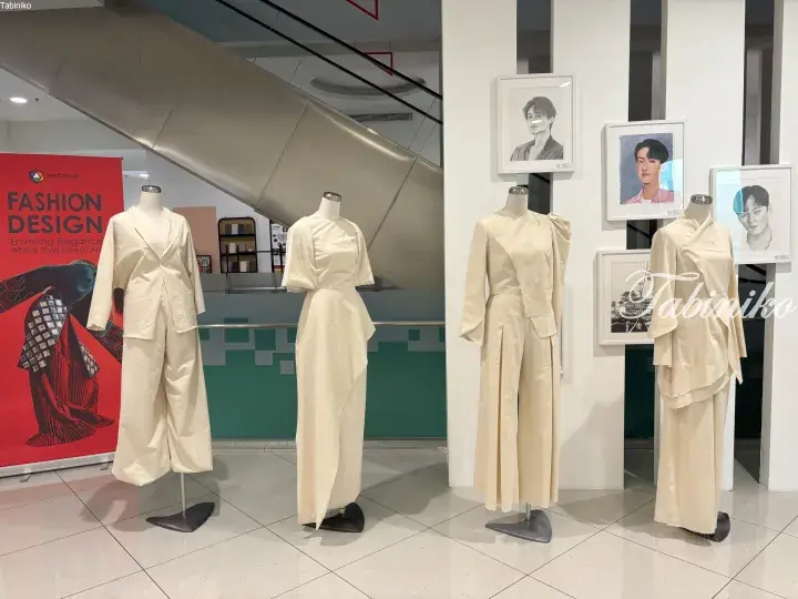 Cream-colored fashion designs displayed on mannequins at Spectrum Fashion Design exhibition.