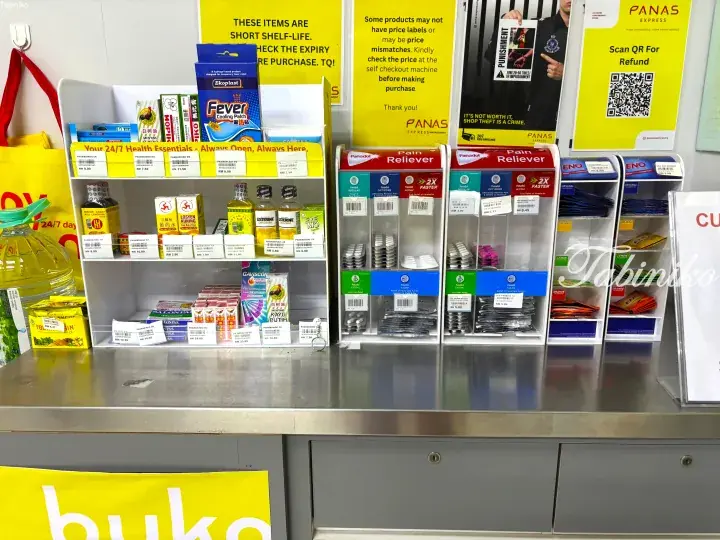 Self-checkout counter at Panas Express convenience store displaying health essentials and pain relievers.