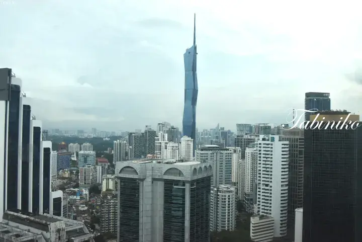 Kuala Lumpur skyline featuring the iconic Merdeka 118 tower rising above surrounding high-rise buildings.