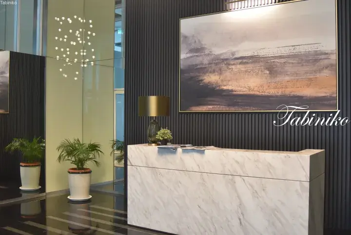 Modern marble reception desk in a luxury lobby with abstract art and potted plants
