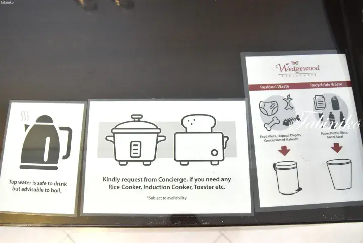 Signage at Wedgewood Residences showing tap water safety, appliance rental options, and waste sorting instructions.