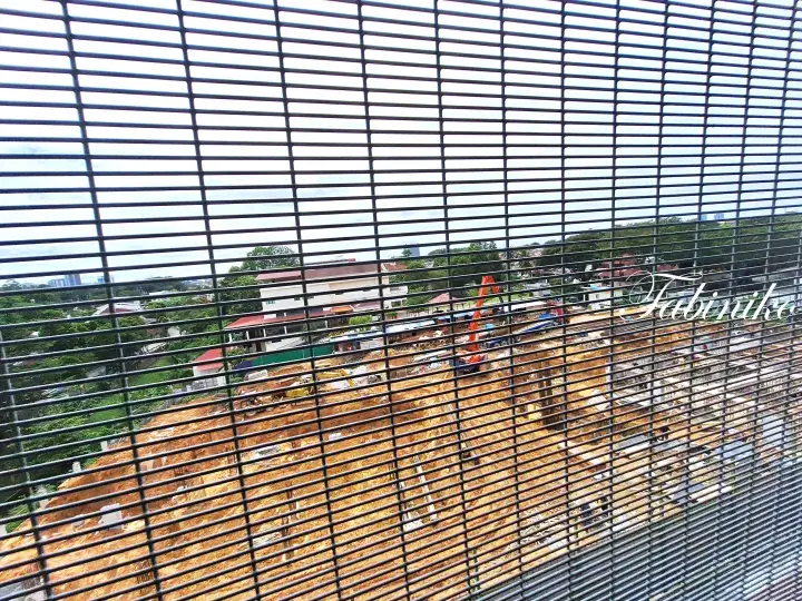 Construction site viewed through window blinds with excavators and earthworks in progress