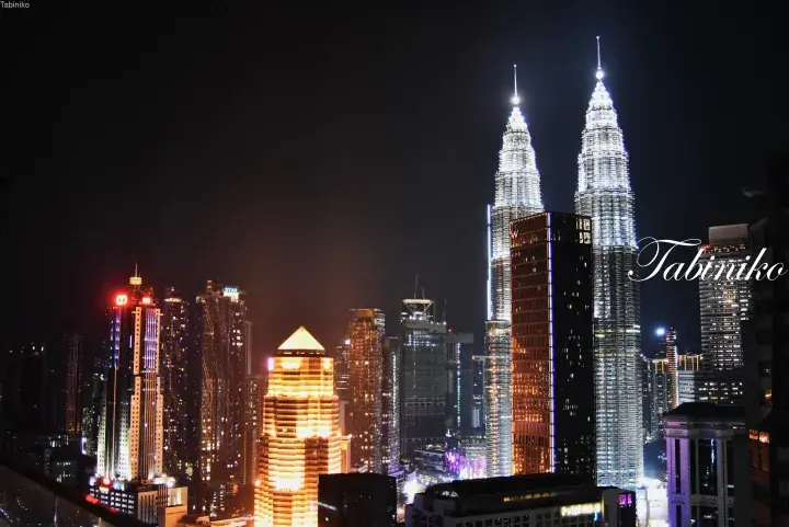 Night view of Kuala Lumpur’s iconic Petronas Twin Towers illuminated against the city skyline.