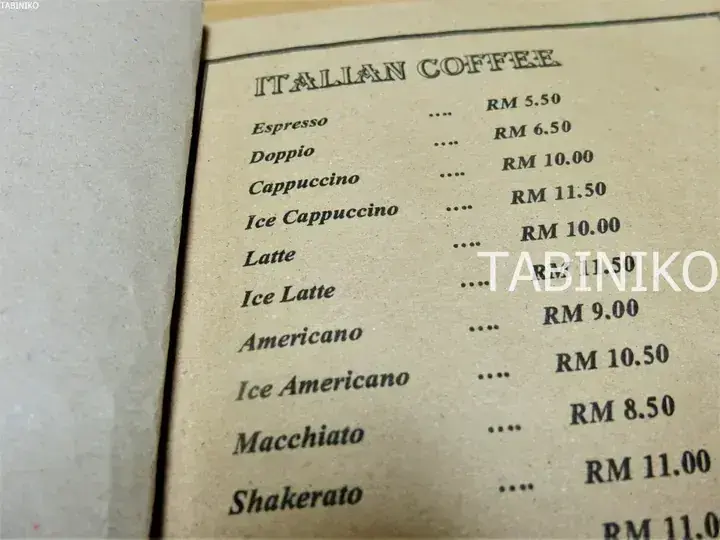 Close-up of an Italian coffee menu listing prices in Malaysian Ringgit, featuring items like Espresso, Cappuccino, and Latte.