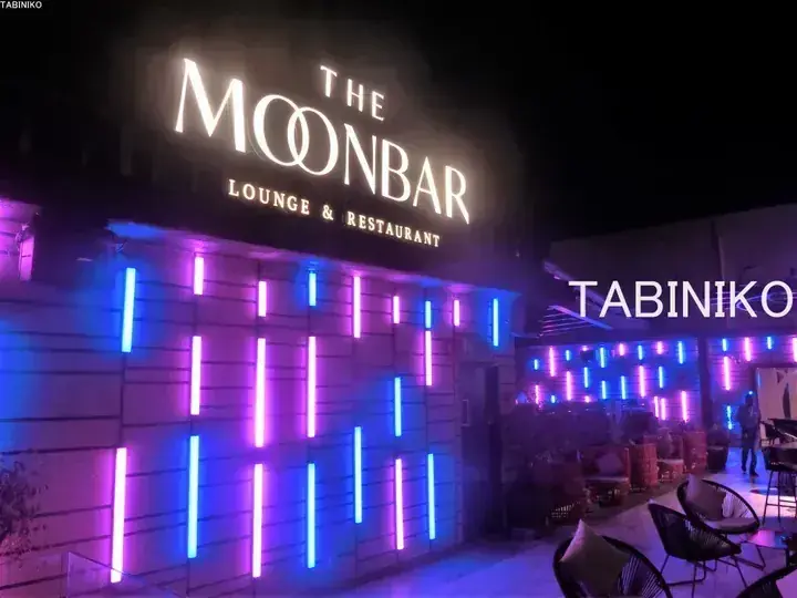 The Moonbar Lounge & Restaurant exterior at night with purple and blue neon lights