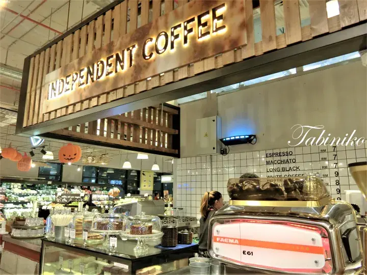 INDEPENDENT COFFEE shop interior with a Faema E61 espresso machine and menu board at a Malaysian market.