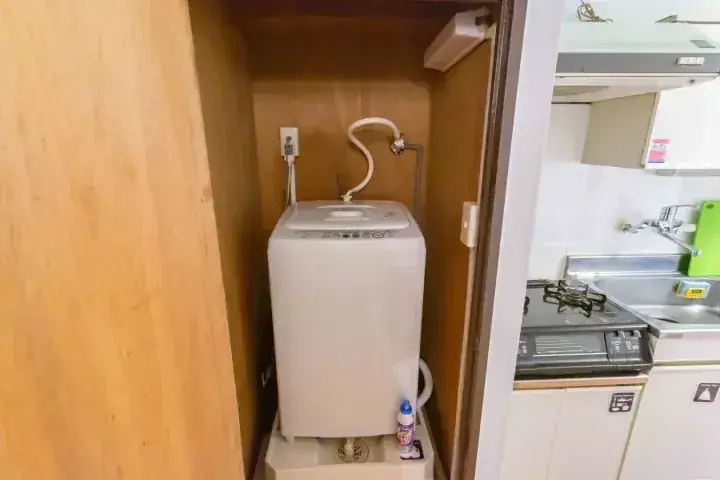 モダンなキッチンの一角にある木製収納スペースに設置された洗濯機。