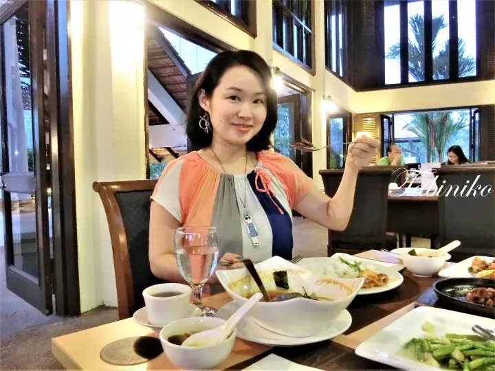 食事をしている女性とテーブルに並んだ料理。