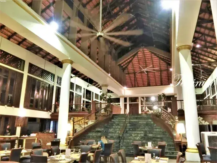 Grand lobby with marble staircase, white columns, and high tiled ceiling at a Malaysian heritage property.