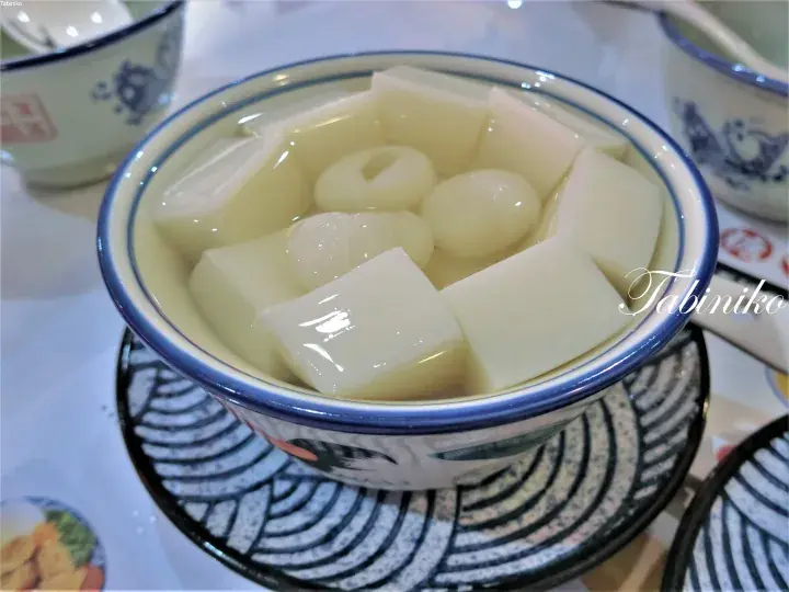A bowl of traditional Malaysian dessert with jelly cubes and longan in sweet syrup.