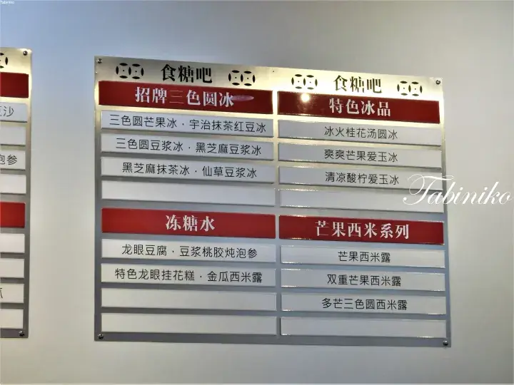 Menu board displaying various dessert options including signature three-color round ice, specialty ice products, and mango sago series.