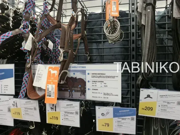 店舗のラックに並ぶ馬具やサドル用品と価格タグ。