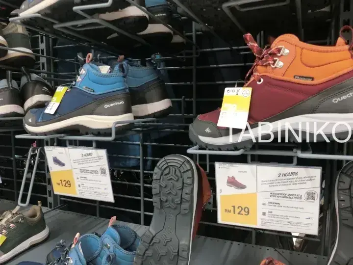 棚に並んだQuechuaのハイキングシューズとRM 129の価格タグ。