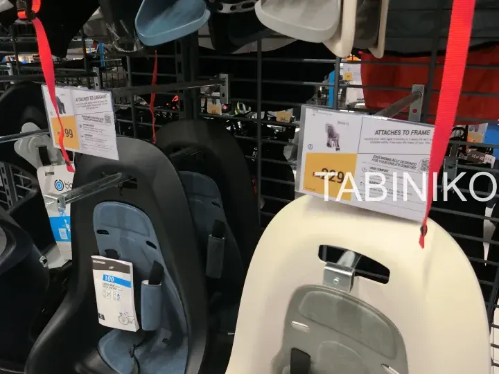 IKEA stroller seats with price tags hanging on a display rack in a store.