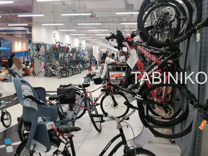 Interior view of a bicycle store with various bikes on display and customers browsing.