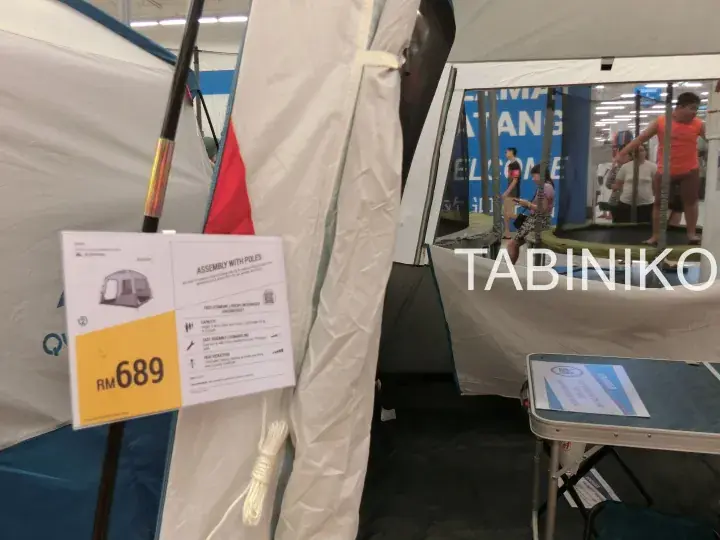 A white tent on display with a price tag showing RM689 and assembly instructions.