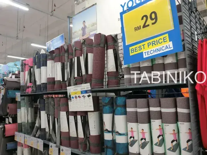 様々な色のヨガマットが棚に並べられ、黄色い値札にRM 29と表示された店舗の棚。