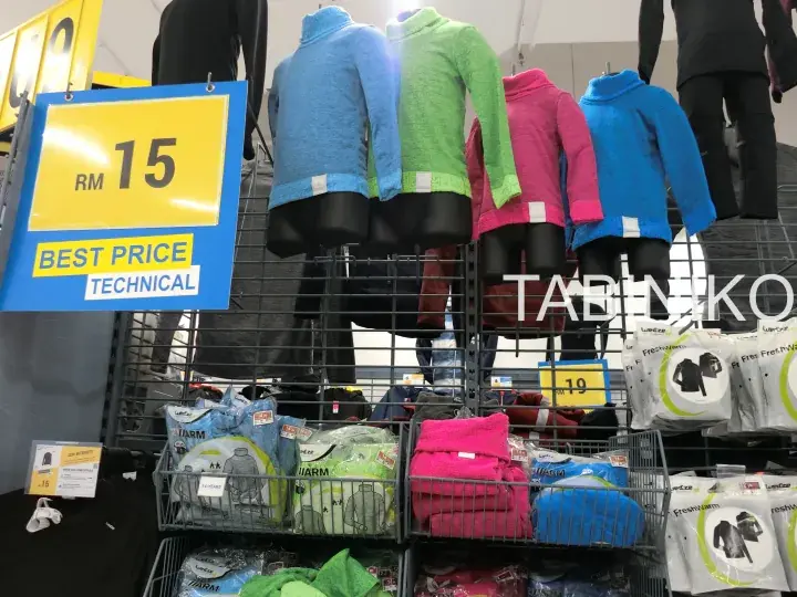 Colorful thermal tops displayed on mannequins with a yellow sign showing RM 15 best price at a retail store.
