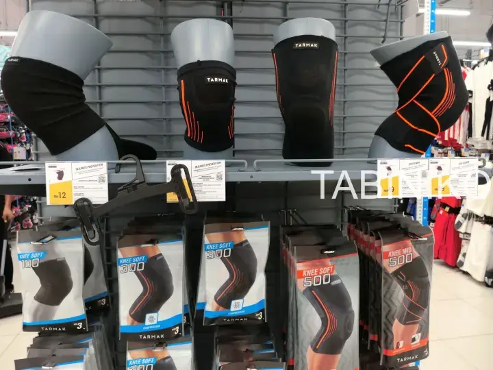 TARMAK knee braces and supports displayed on retail store shelves with price tags and packaging.