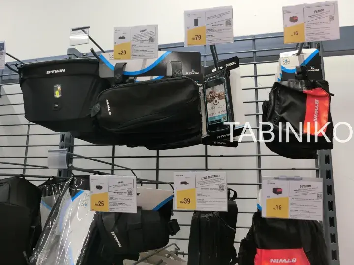 Bike accessories like STWIN bags and phone mounts displayed on a store rack with price tags.