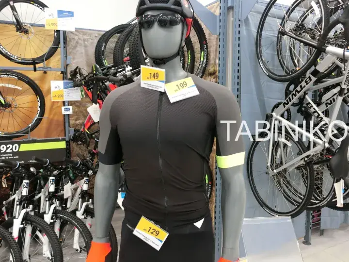 Mannequin wearing cycling gear with price tags in a bike shop