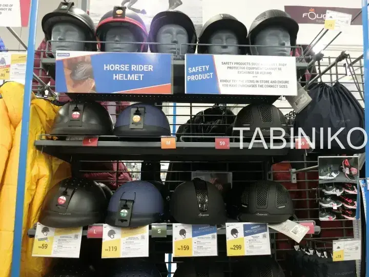店舗で陳列されたホースライダーヘルメットと安全製品、価格表示付きマネキン頭部。