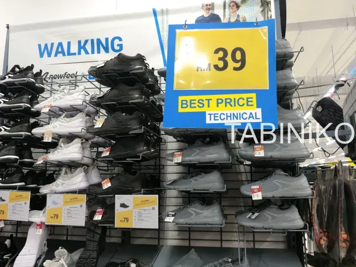 Shoes display at Decathlon with a yellow sign showing RM 39 best price for technical walking shoes.