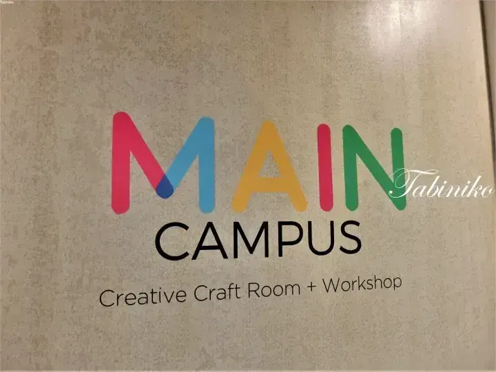 色とりどりの文字で書かれた「MAIN CAMPUS Creative Craft Room + Workshop」の看板と「Tabiniko」の透かし