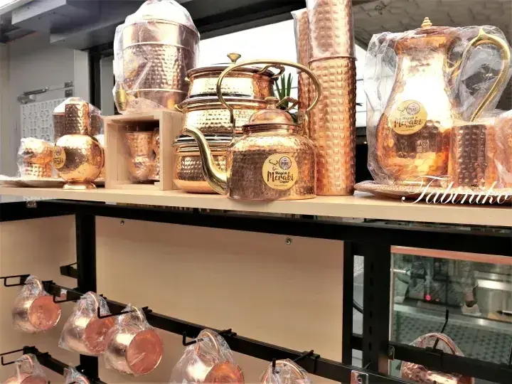 Tabiriko店内の棚に並んだ手打ち銅製ティーセットとタンブラー。