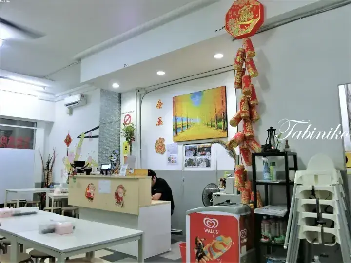 カウンターやテーブル、装飾が施されたマレーシアのカフェの店内。ウォリーズのアイスクリームフリーザーが映る。