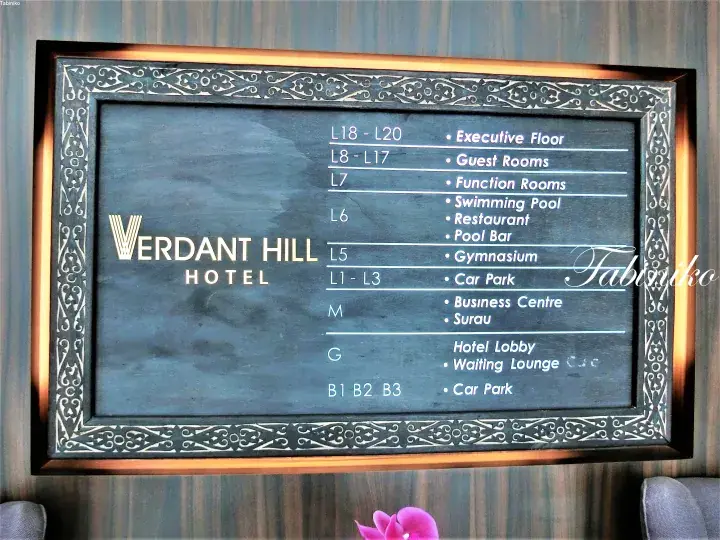 Verdant Hill Hotel directory sign listing floors for guest rooms, pool, gym, and car park.