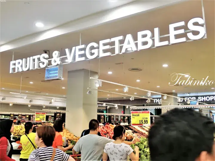 Customers shopping in the Fruits & Vegetables section of a supermarket in Malaysia.