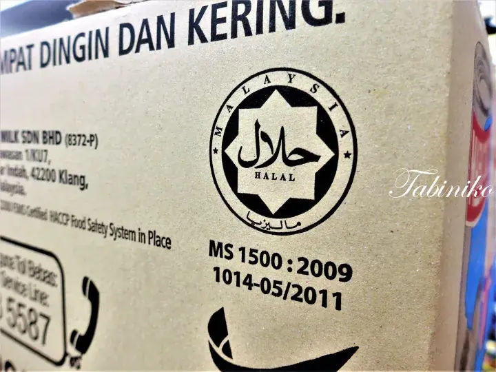 Close-up of a cardboard box showing the Malaysia Halal certification logo and MS 1500:2009 standard text.