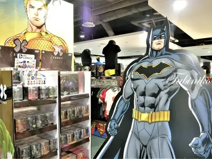 DCコミックの販促グッズが並ぶ店内に設置されたバットマンの等身大パネル。