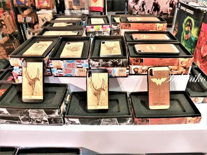 Wooden phone cases with laser-engraved designs including Wonder Woman logo and deer antlers displayed in retail boxes.