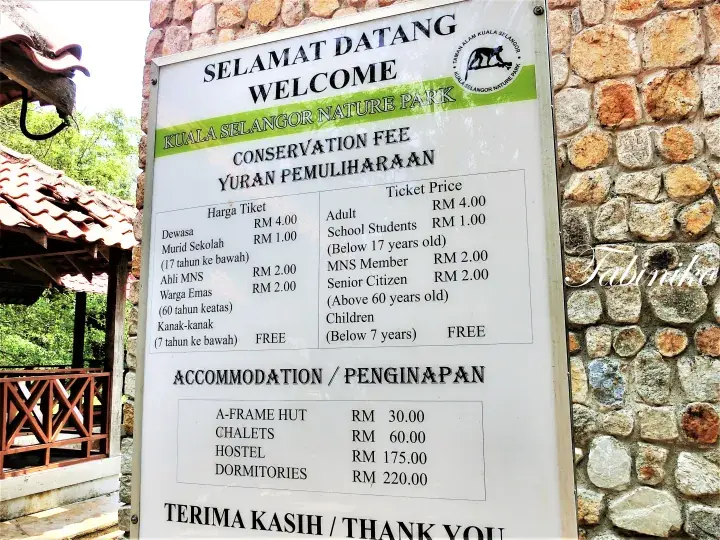 Welcome sign for Kuala Selangor Nature Park showing conservation fees and accommodation rates.