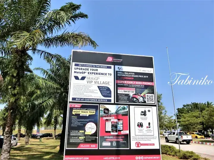 青空の下、MotoGP VIP VillageやShell Malaysia Motorcycle Grand Prix 2019を宣伝するセパンサーキットの看板。