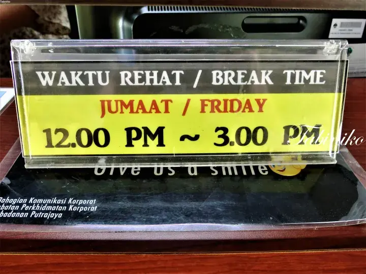 A clear acrylic sign displaying the Friday break time from 12.00 PM to 3.00 PM for Badan Putrajaya.