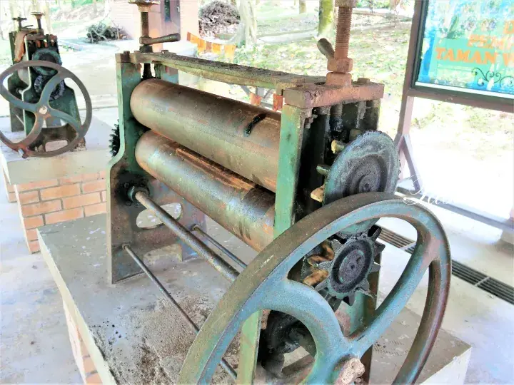Vintage industrial machinery with large gears and rollers displayed at Taman Tasik Titiwangsa in Kuala Lumpur.