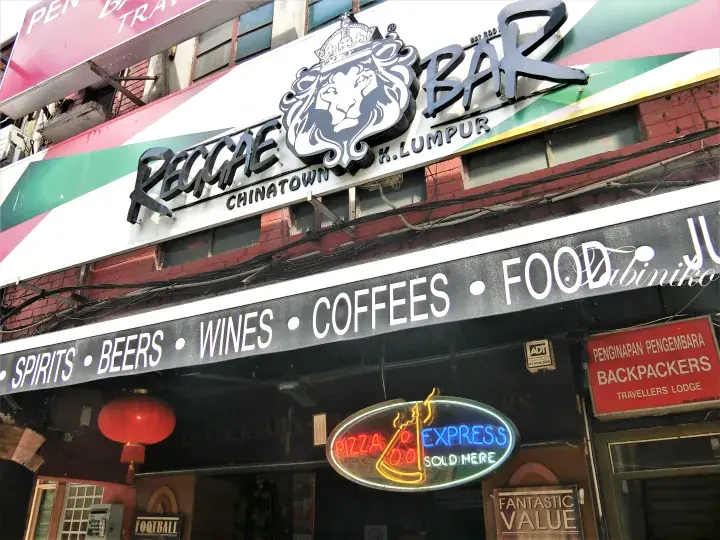 Reggae Bar Chinatown Kuala Lumpur exterior sign featuring a lion logo and listings for spirits, beers, coffees, and food.