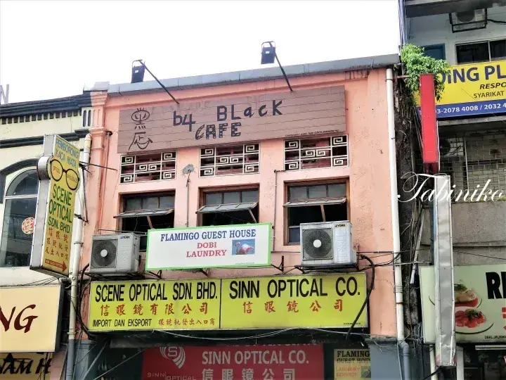 マレーシアのピンクの店屋敷で、b4 Black CAFE、Flamingo Guest House、Scene Optical Sdn. Bhd.の看板が見えます。